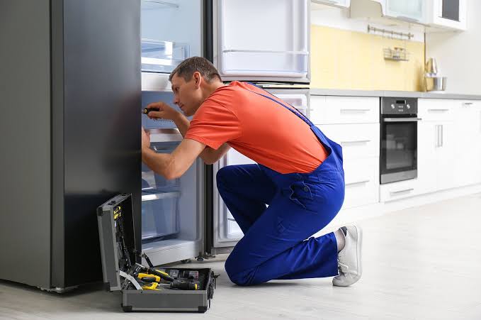 Technician inspecting the freezer drawers of a refrigerator-freezer