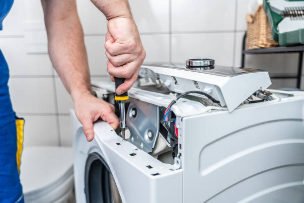 Close-up of a technician repairing the exposed components of a washing machine