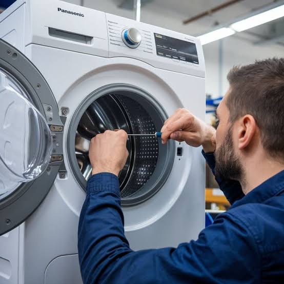 Technician carefully repairing the drum of a front-loading washing machine